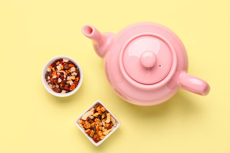 Ceramic teapot bowls of dried fruits on yellow backgroundの写真素材