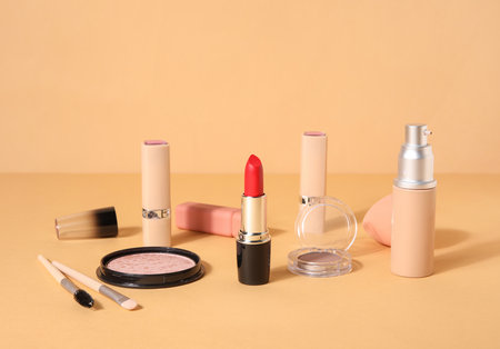 Lipsticks and different cosmetics on beige backgroundの写真素材