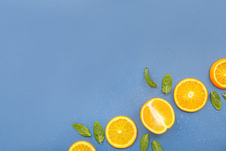 Orange slices and mint on blue background