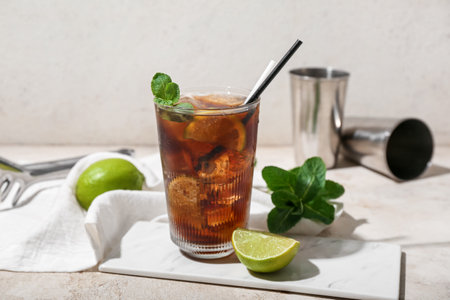 Glass of tasty Cuba Libre cocktail on light backgroundの写真素材