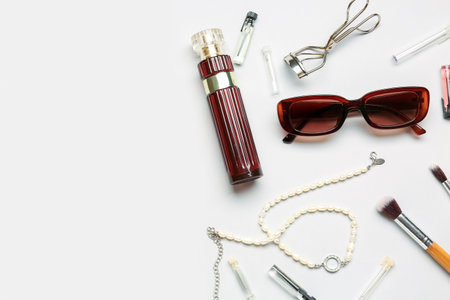 Sunglasses with perfume, jewelry and makeup brushes on white backgroundの写真素材