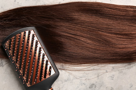 Brown hair with brush on grunge background, closeupの写真素材