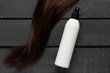 Brown hair with spray on dark wooden backgroundの写真素材