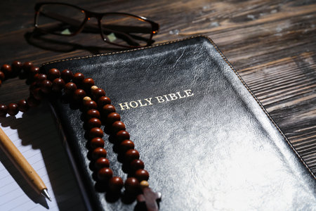 Holy Bible with prayer beads on wooden background, closeupの写真素材