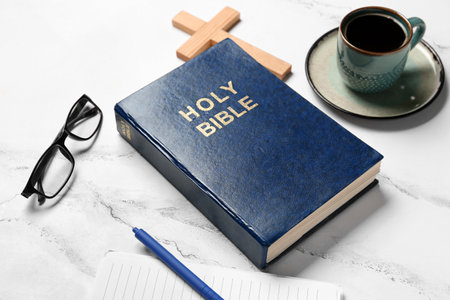 Holy Bible, eyeglasses and cup of coffee on white marble backgroundの写真素材