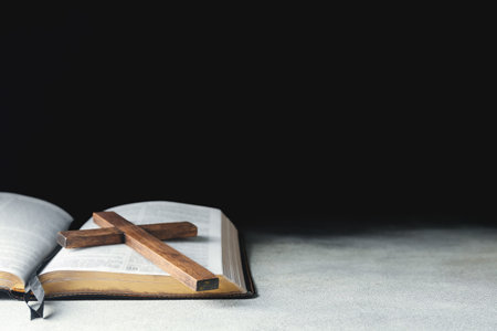 Holy Bible with wooden cross on dark backgroundの写真素材