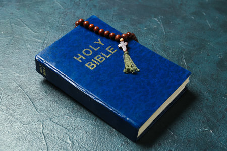 Holy Bible with prayer beads on dark backgroundの写真素材