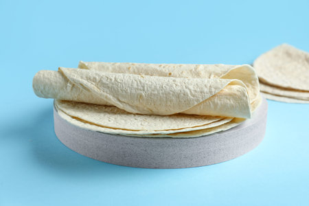 Board with thin lavash on blue background