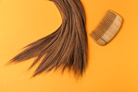 Brown hair with comb on color backgroundの写真素材