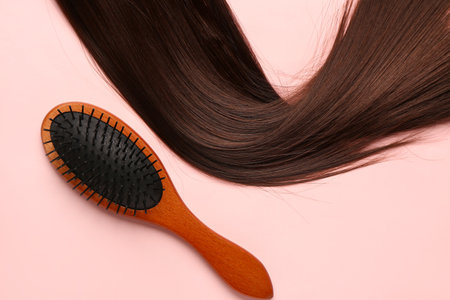 Brown hair with brush on pink backgroundの写真素材