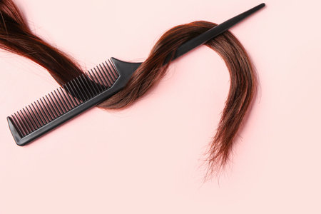 Brown hair with brush on pink backgroundの写真素材