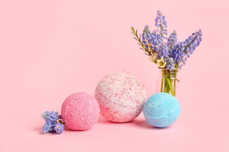 Bath bombs and vase with flowers on pink backgroundの写真素材