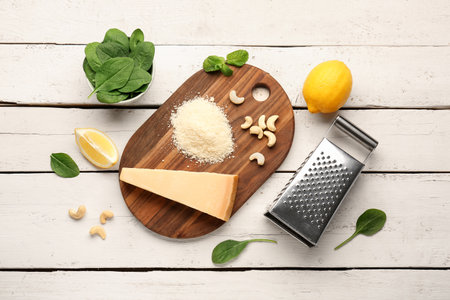 Board with tasty Parmesan cheese and grater on light wooden backgroundの写真素材