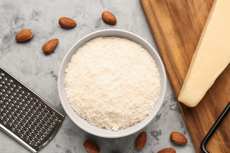 Bowl with tasty Parmesan cheese on grunge backgroundの写真素材