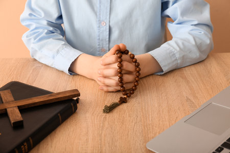 Woman with prayer beads at table on beige background, closeupの写真素材