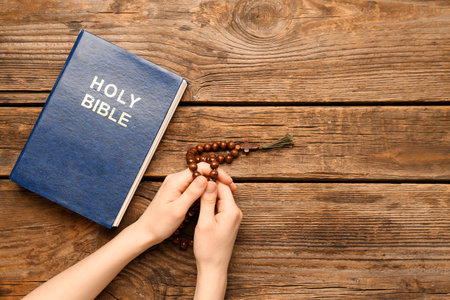 Woman with prayer beads and Holy Bible on wooden backgroundの写真素材