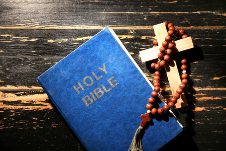 Holy Bible with prayer beads and cross on dark wooden backgroundの写真素材