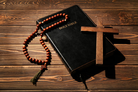 Holy Bible with cross and prayer beads on wooden backgroundの写真素材