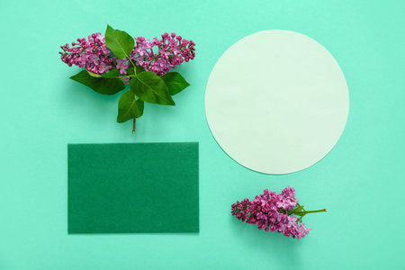 Composition with blank cards and lilac flowers on turquoise background