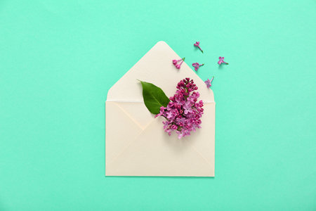 Envelope and lilac flowers on turquoise backgroundの写真素材