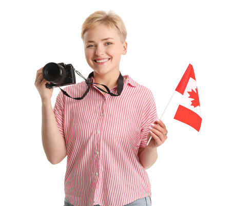 Young woman with photo camera and flag of Canada on white backgroundの写真素材
