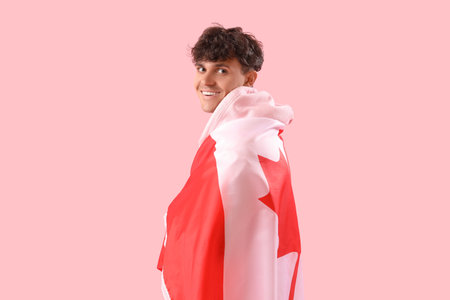 Young man with flag of Canada on pink backgroundの写真素材