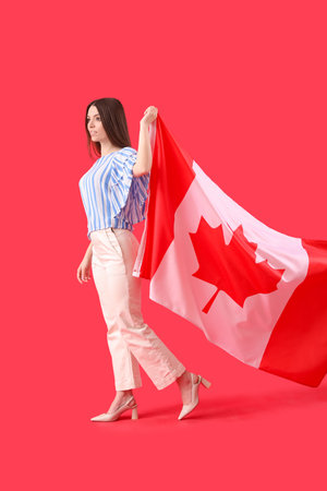 Young woman with flag of Canada on red backgroundの写真素材