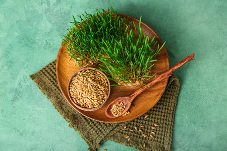 Fresh wheatgrass with wooden board on green grunge tableの写真素材
