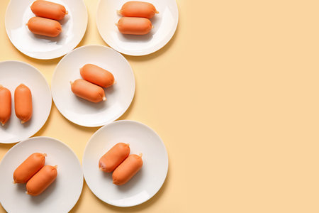 Plates of tasty boiled sausages on beige backgroundの写真素材