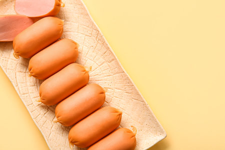 Plate of tasty boiled sausages on beige backgroundの写真素材