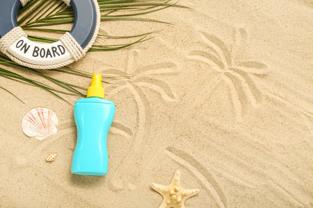 Creative composition with sunscreen cream, lifeline and palm leaf on sand