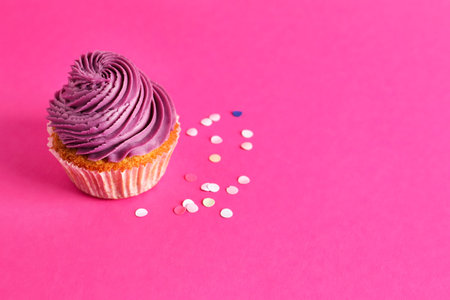 Tasty cupcake with confetti on pink backgroundの写真素材