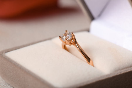 Box with engagement ring on white background, closeup