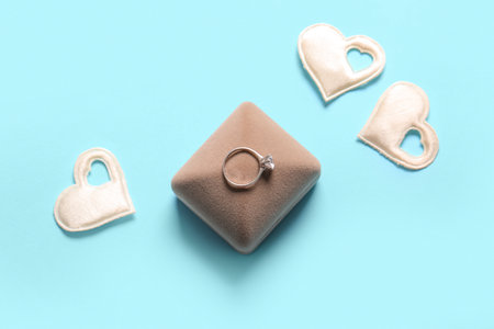 Box with engagement ring and hearts on blue backgroundの写真素材