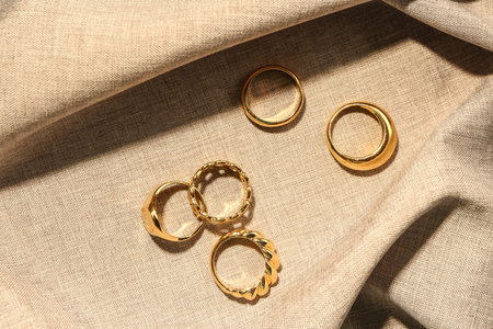 Beautiful rings on beige fabric background