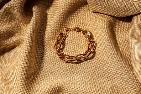 Beautiful chain bracelet on beige fabric backgroundの写真素材