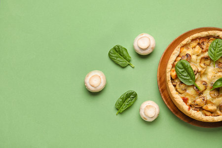 Mushroom pie with spinach leaves and champignons on green backgroundの写真素材