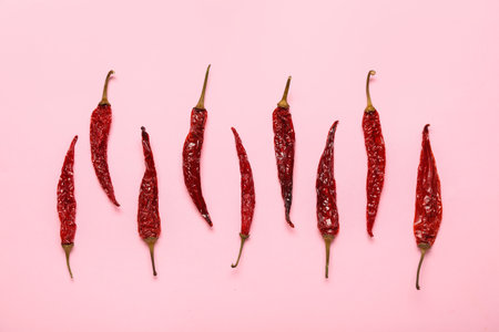 Dry hot chili peppers on pink backgroundの写真素材