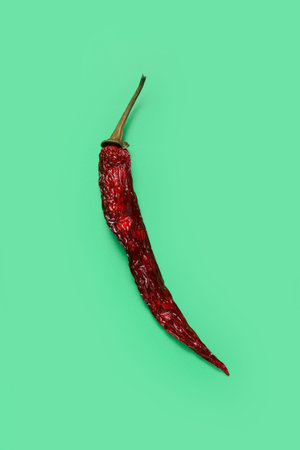 Dry hot chili pepper on green background