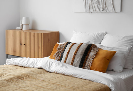 Interior of stylish bedroom with cozy bed and wooden cabinetの写真素材