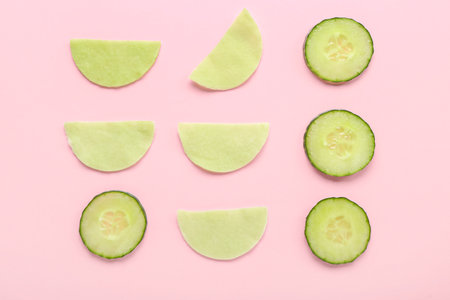 Cotton under-eye patches with cucumber slices on pink backgroundの写真素材