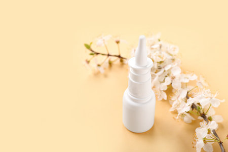 Nasal drops with blooming branch on beige background, closeup. Seasonal allergy conceptの写真素材