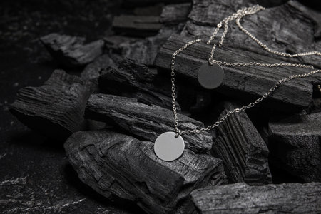 Silver necklaces on black charcoal, closeupの写真素材