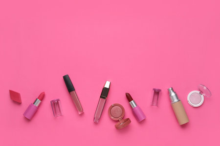 Decorative cosmetics with lipsticks and sponge on pink backgroundの写真素材