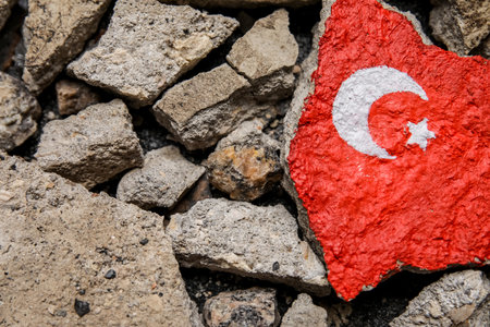 Stone debris with painted Turkish flag on dark background. Turkey earthquake conceptの写真素材