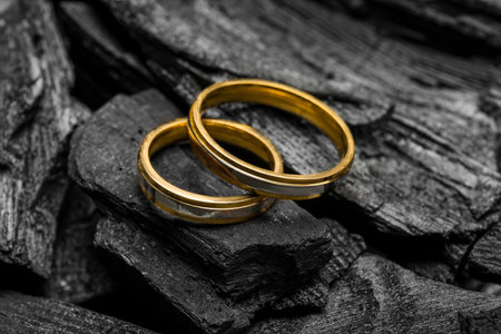 Wedding rings on black charcoal, closeupの写真素材