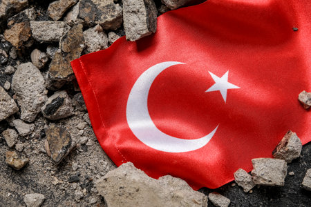 Turkish flag with stone debris on dark background. Turkey earthquake conceptの写真素材