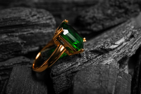 Golden ring on black charcoal, closeupの写真素材