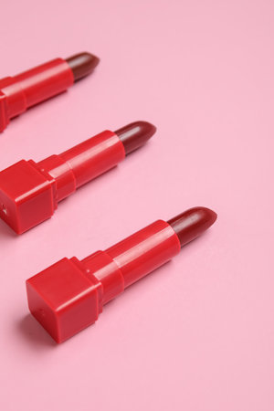 Red lipsticks on pink background, closeup