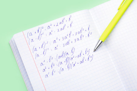 Copybook with maths formulas and pen on green backgroundの写真素材